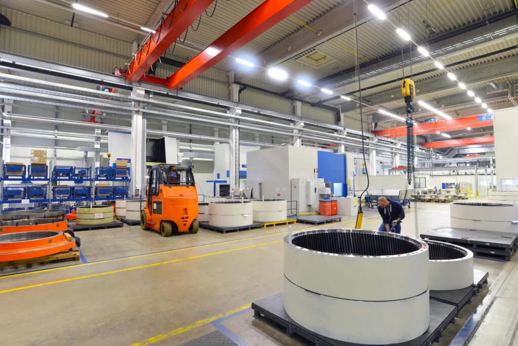 Factory of modern mechanical engineering - production of gearboxes for wind turbines - worker at cnc milling machine